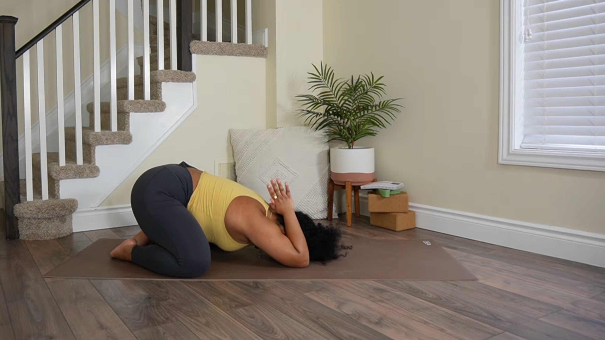Yoga teacher practicing Child's Pose variation.
